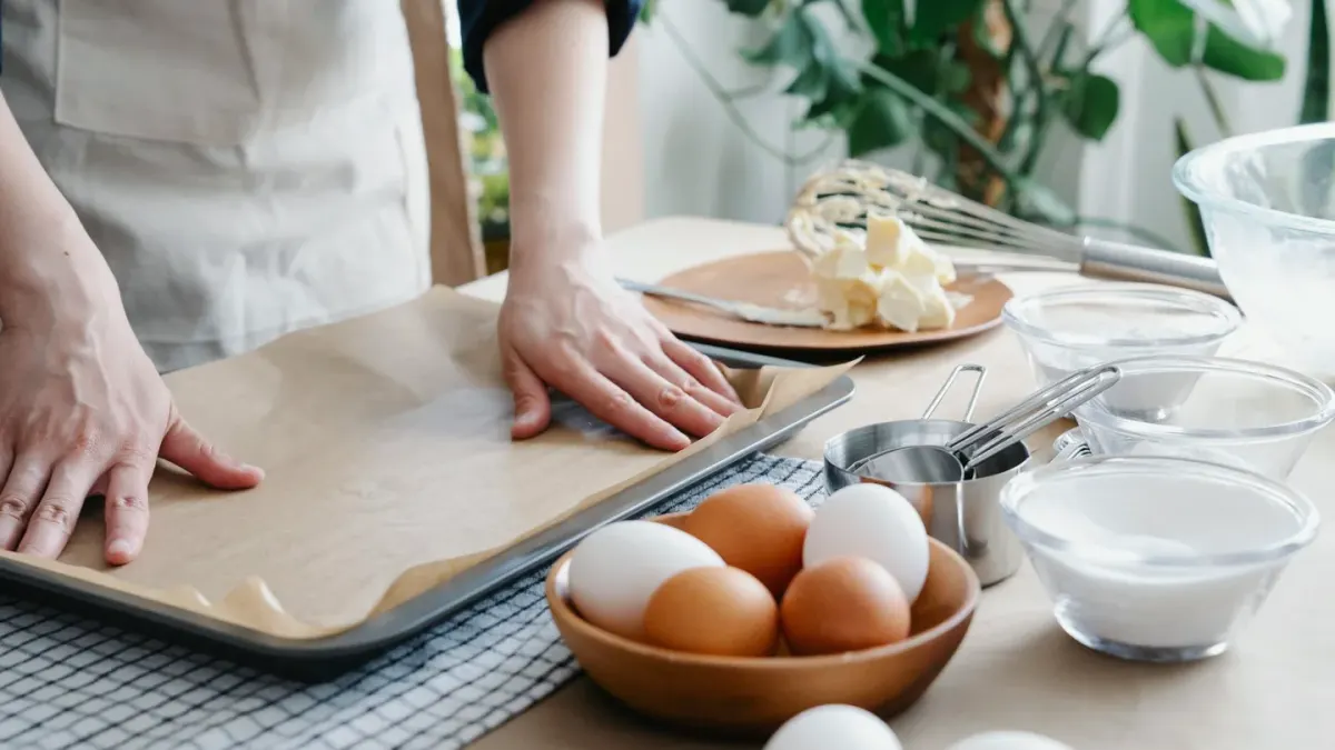 A dog watching an owner portion out fresh ingredients on a kitchen counter