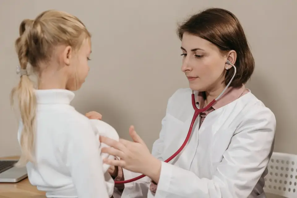 A veterinarian using a stethoscope to check a small dog&#x27;s breathing